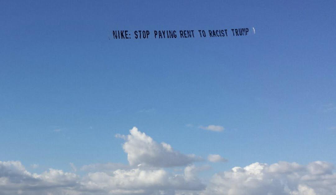UltraViolet plane over Nike, banner text: STOP PAYING RENT TO RACIST TRUMP.