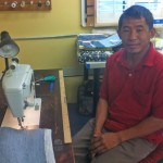Damber Pulami, originally from Nepal, is a re:loom weaver who uses a sewing machine to finish an item woven from recycled materials. He wove the rug and scarf from Spanx remnants that caught the eye of that company's owner, Sara Blakely.
