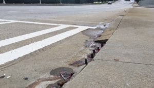 Rebar sticks up like teeth out of Capitol Avenue in Downtown where a curb cut belongs.