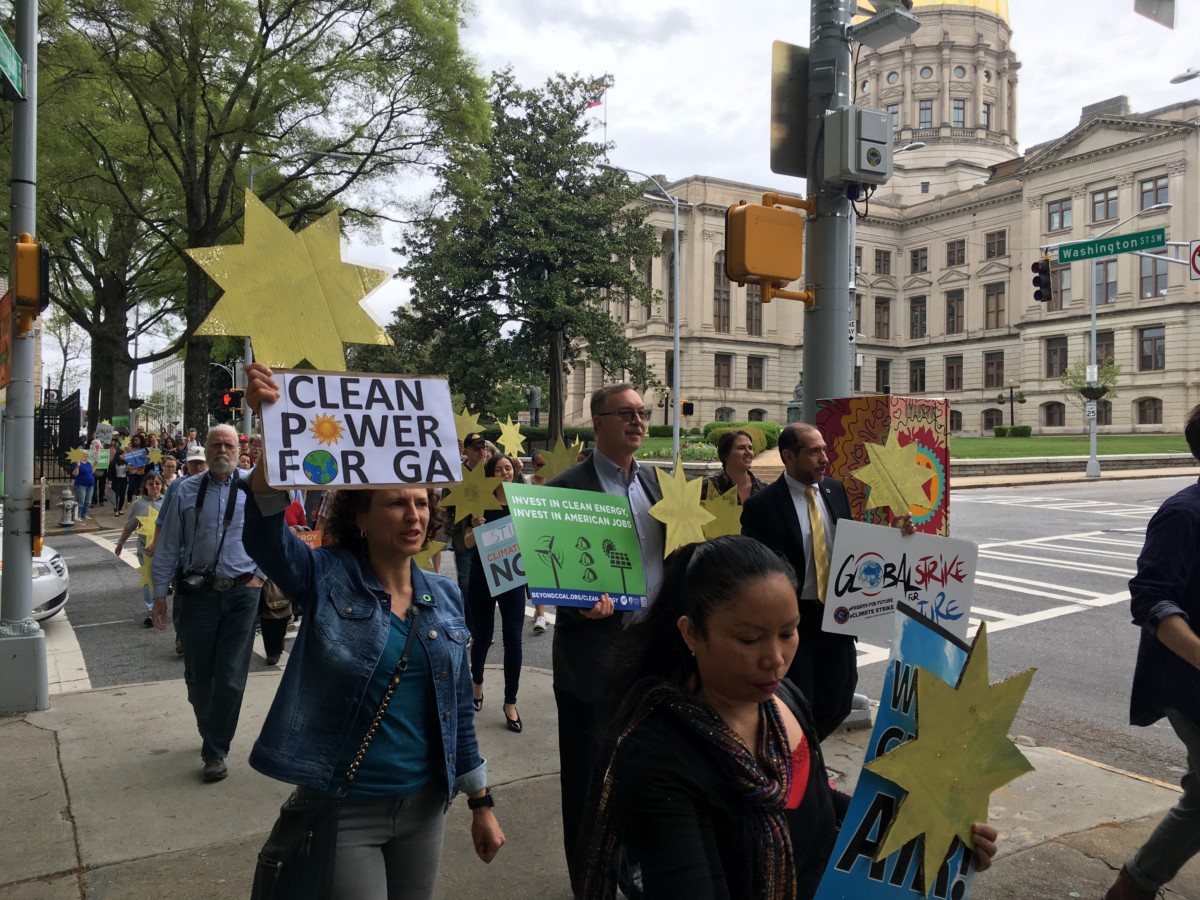 Folks demanding cleaner, more affordable energy marched past the state Capitol en route to a short demonstration at the next-door Public Service Commission on April 8. Credit: Maggie Lee