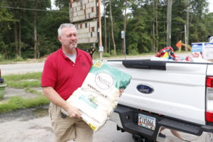 A man carrying a bag of pet food.