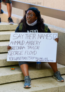Protestor with "say their names" sign