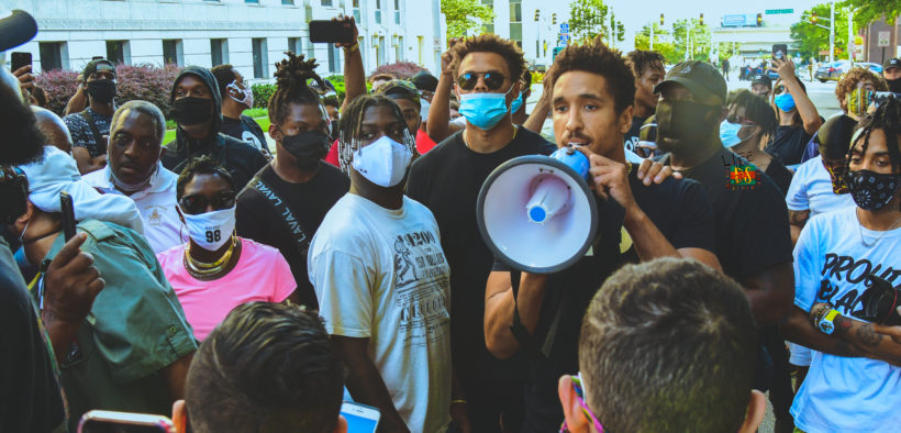 Man with megaphone addresses crowd around him