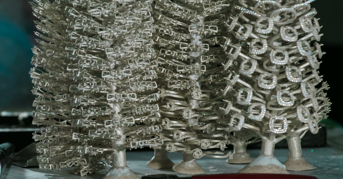 Jewelry ring trees with silver settings and gems.