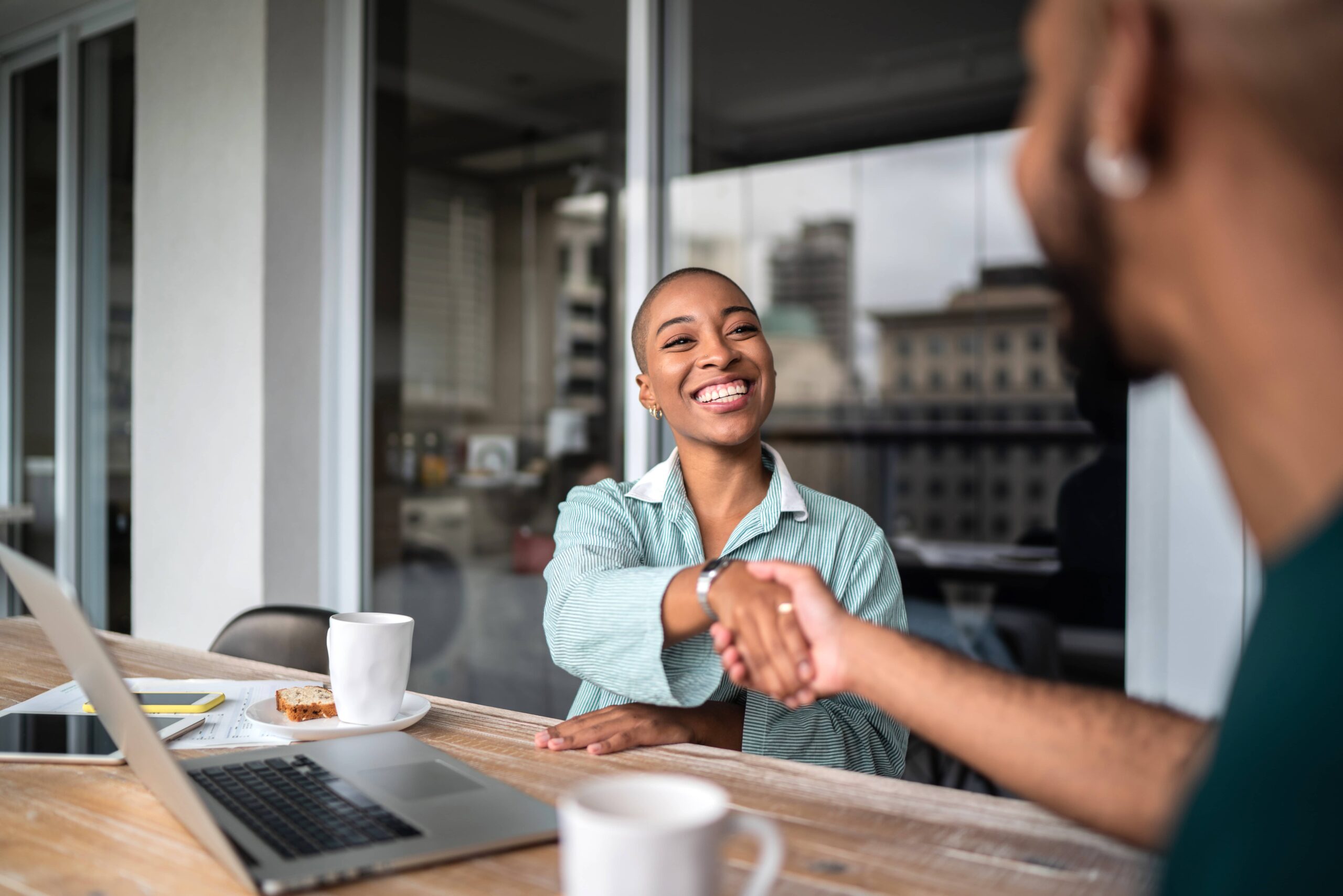 Woman entrepreneur shaking hands, meeting with her business mentor
