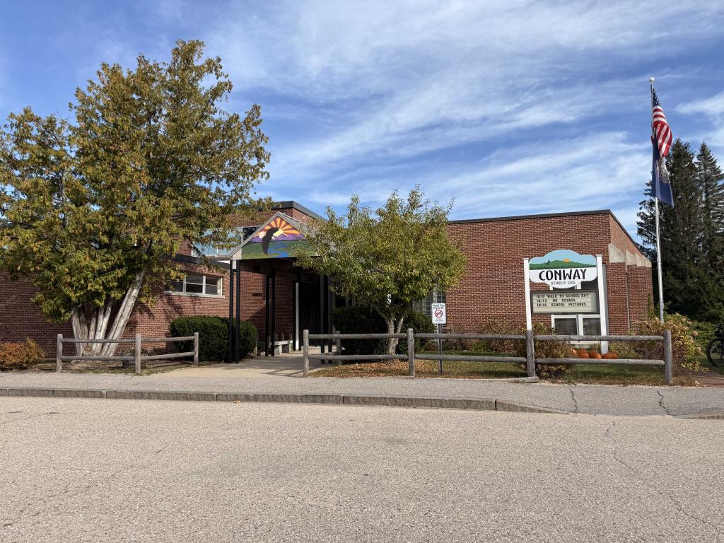 The Conway Elementary School building is shown on a sunny day with a blue sky.