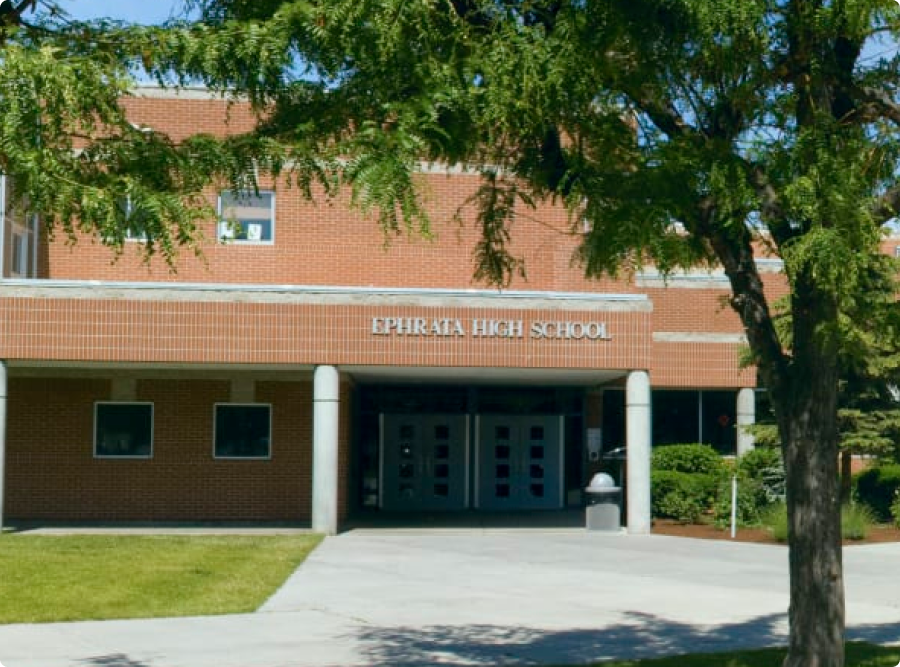 Exterior view of a brick building with the words 'Riverside High School' above the entrance.