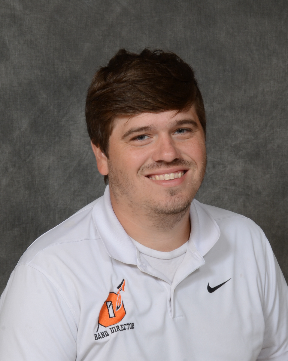 A smiling man with brown hair poses for a portrait.
