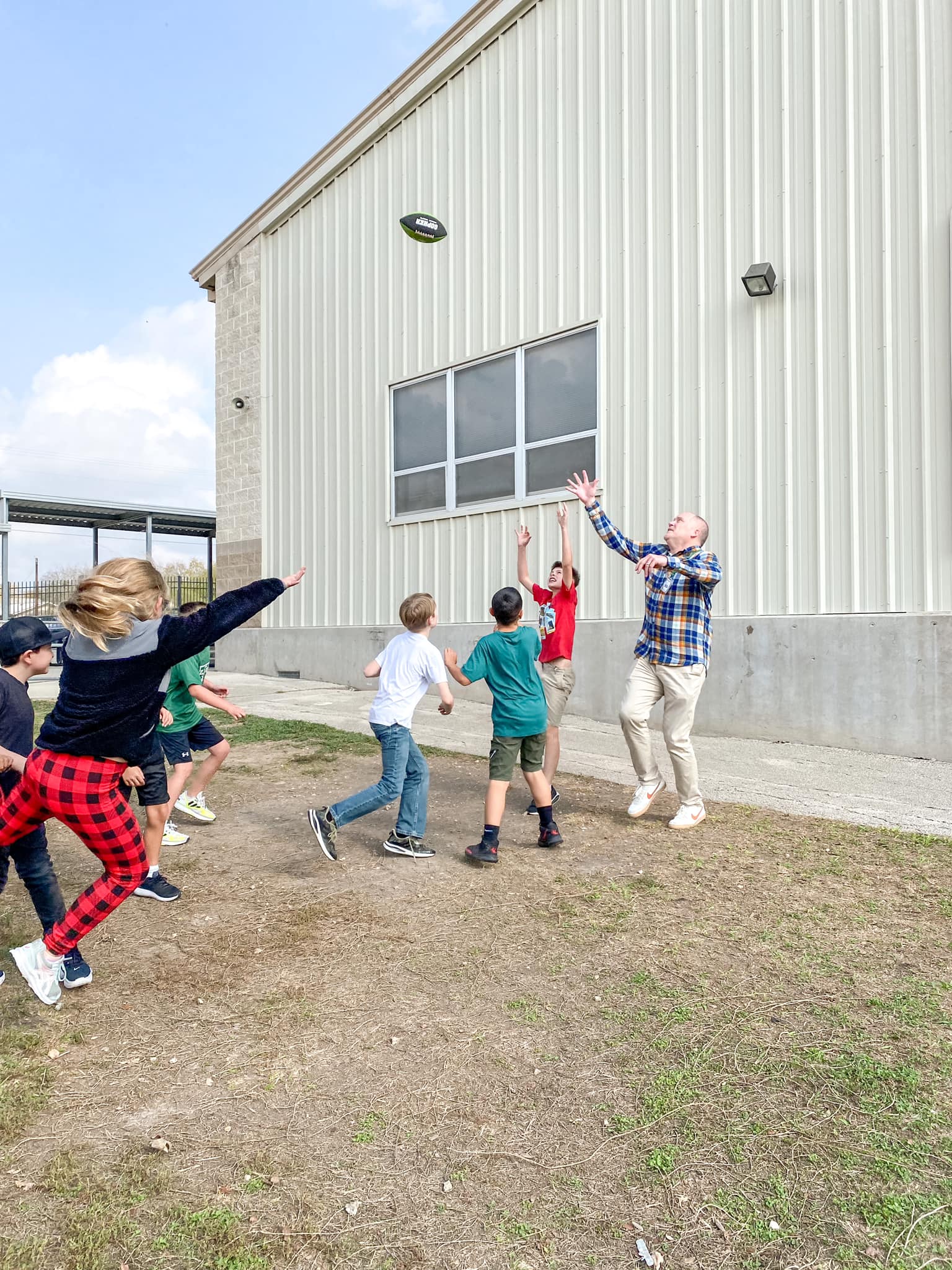 superintendent and students playing football