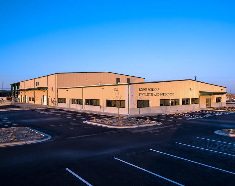 Exterior view of the Boise Facilities and Operations building with a large parking area.