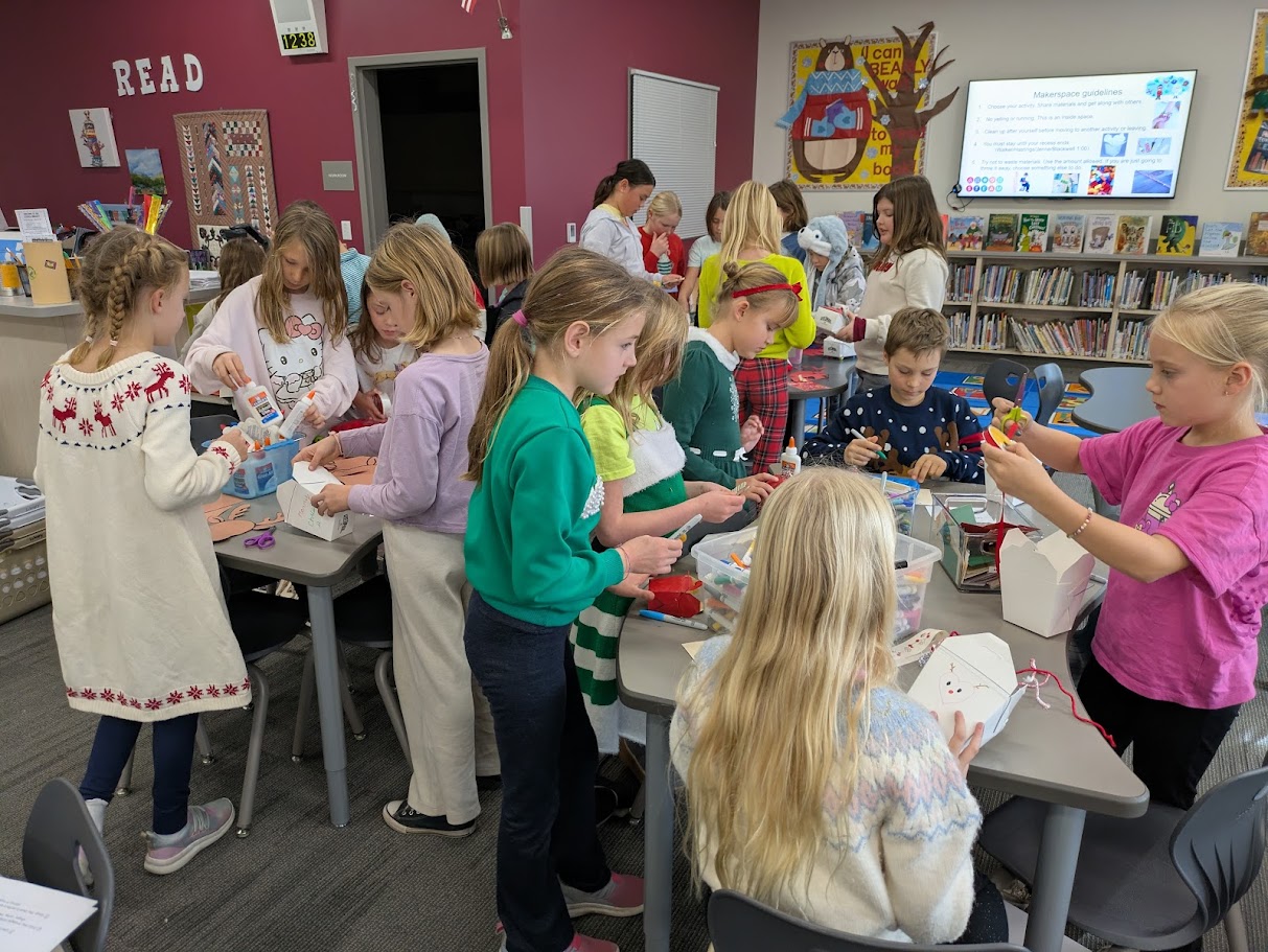 Children and adults gather around tables, engaged in a craft activity.