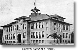 A vintage black and white photo of a large brick school building.