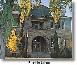 A historic building, Franklin School, is framed by trees.