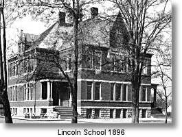 A historic brick building, Lincoln School 1896, stands framed by trees.