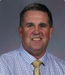 A man with short, graying hair smiles at the camera.