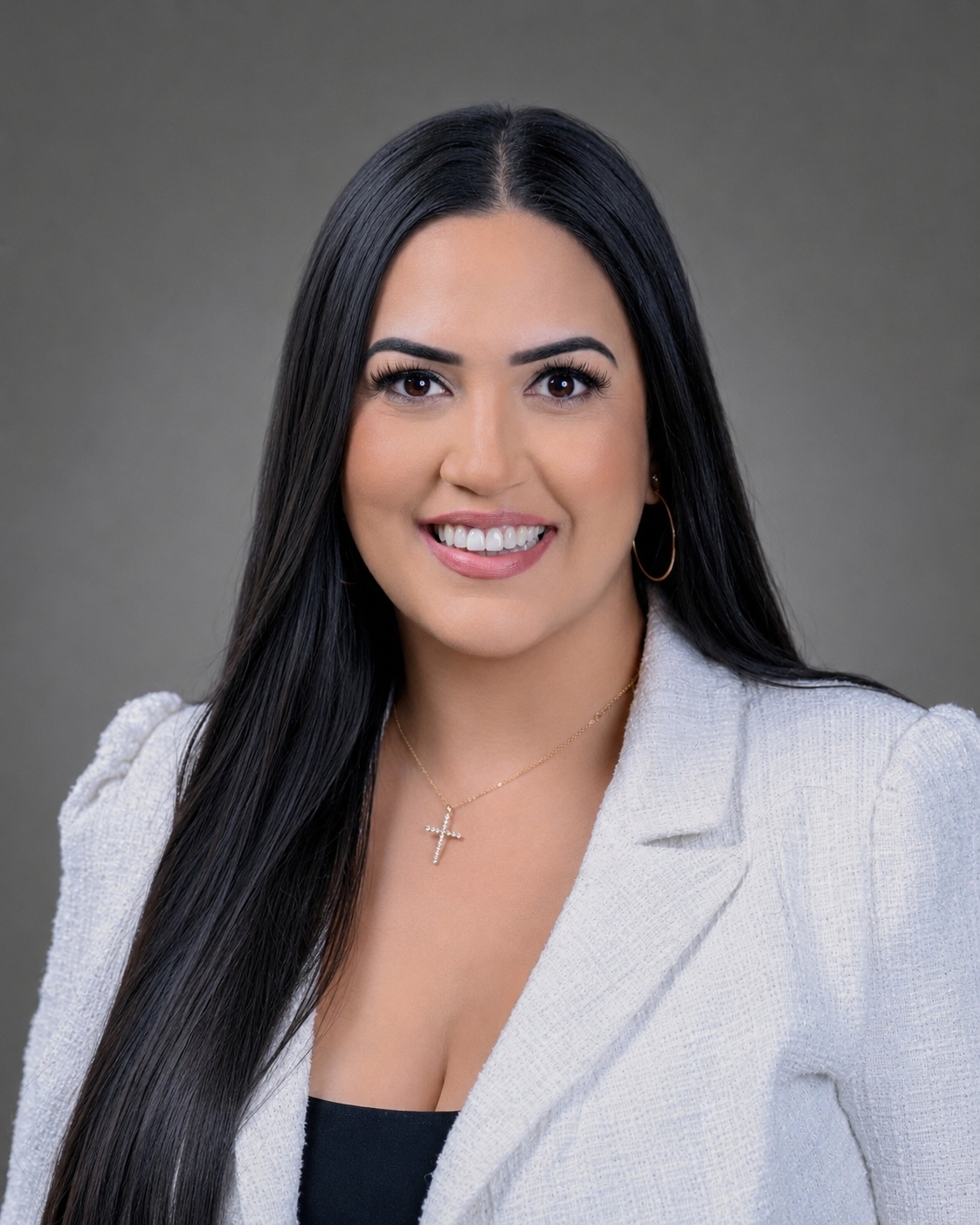A professional portrait of a woman with long, dark hair wearing a white blazer.
