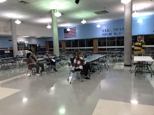 Students and parents listen to a speaker about the tech programs. 