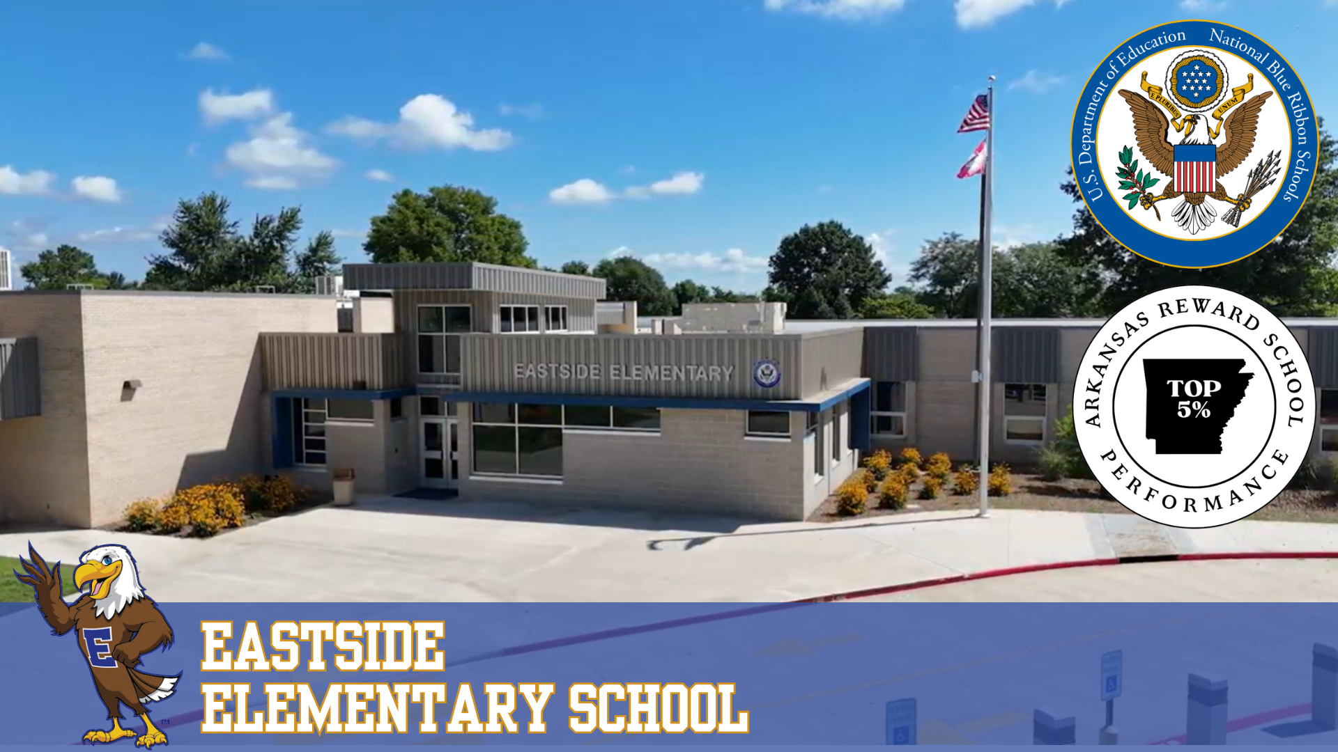 Exterior view of Eastside Elementary School with a mascot and official seals.