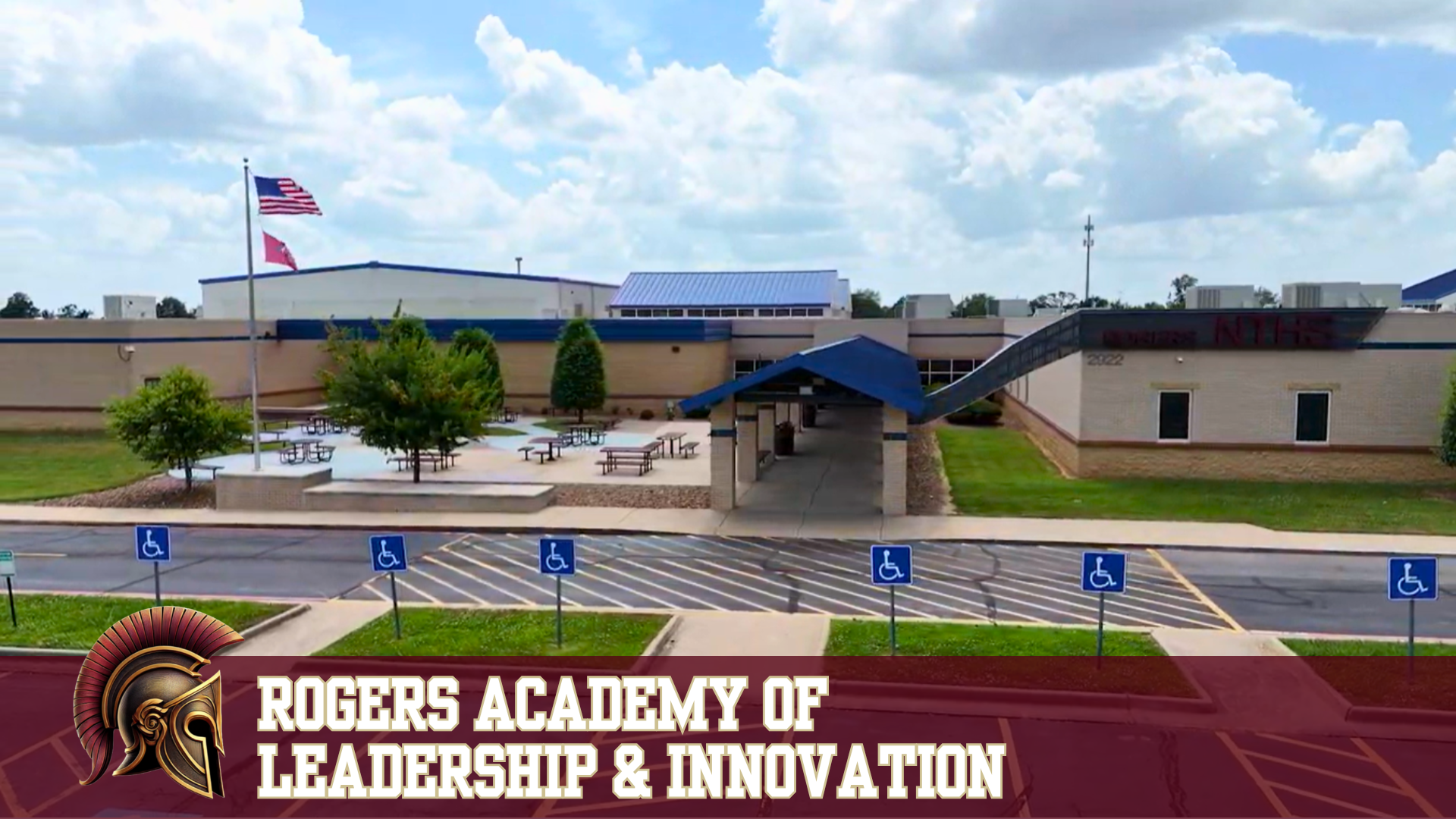 Exterior view of Rogers Academy of Leadership & Innovation school building with American and state flags.