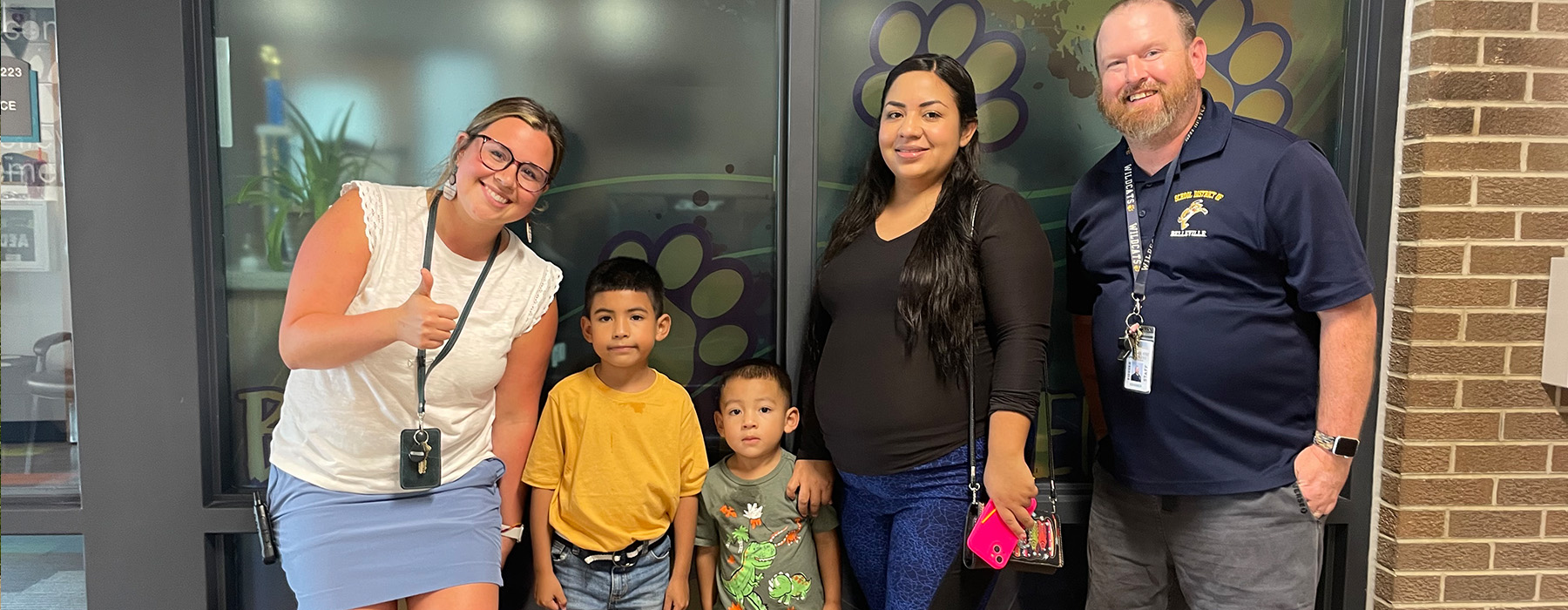 Two adults and two children pose for a photo in front of a building.