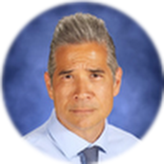 A headshot of a man with graying hair and a light blue collared shirt and tie.