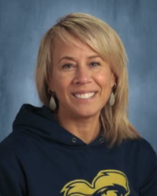 A smiling woman with blonde hair wears a navy blue hooded sweatshirt.