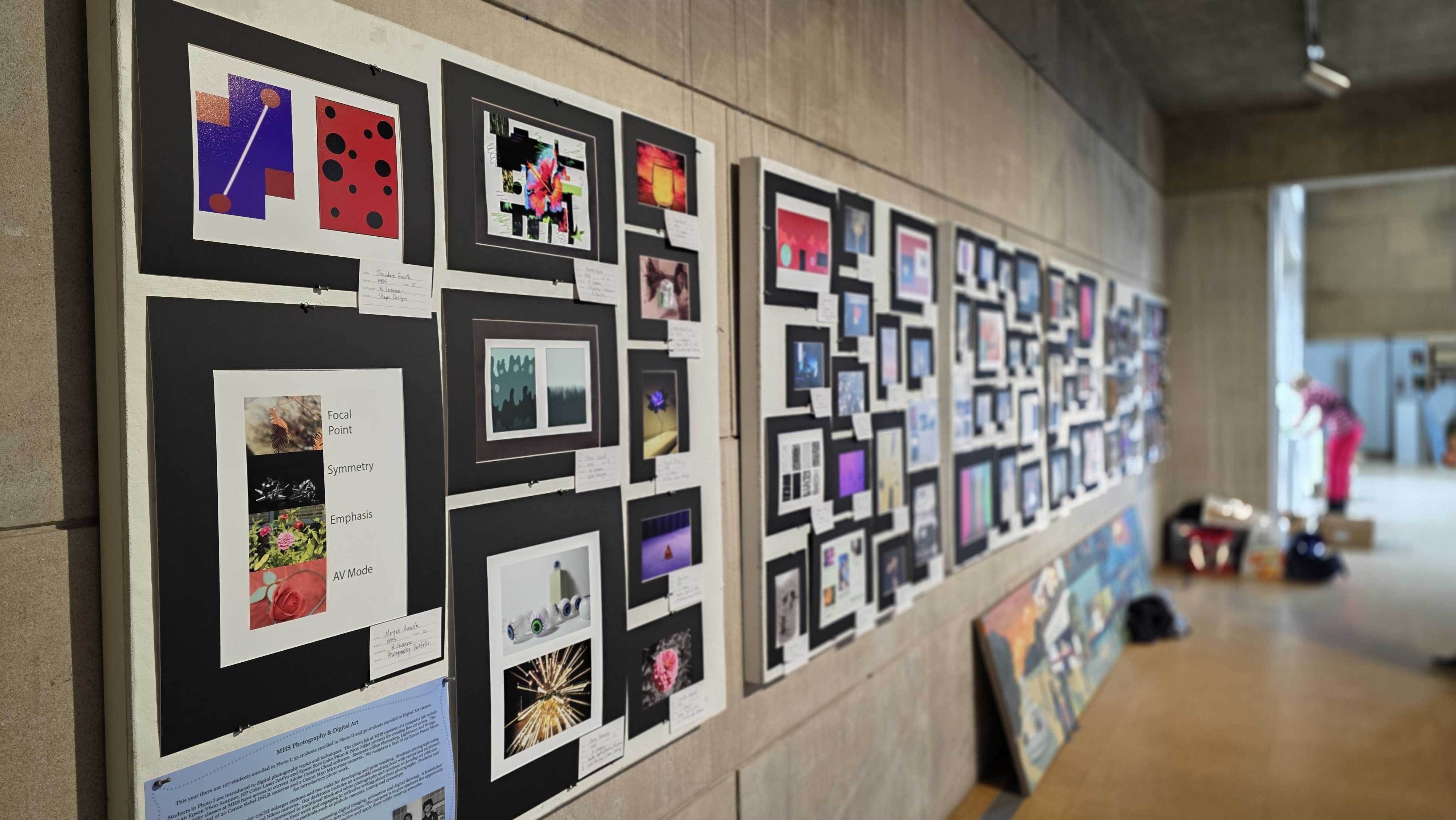A long wall displays a diverse collection of framed photographs, creating an art exhibition.