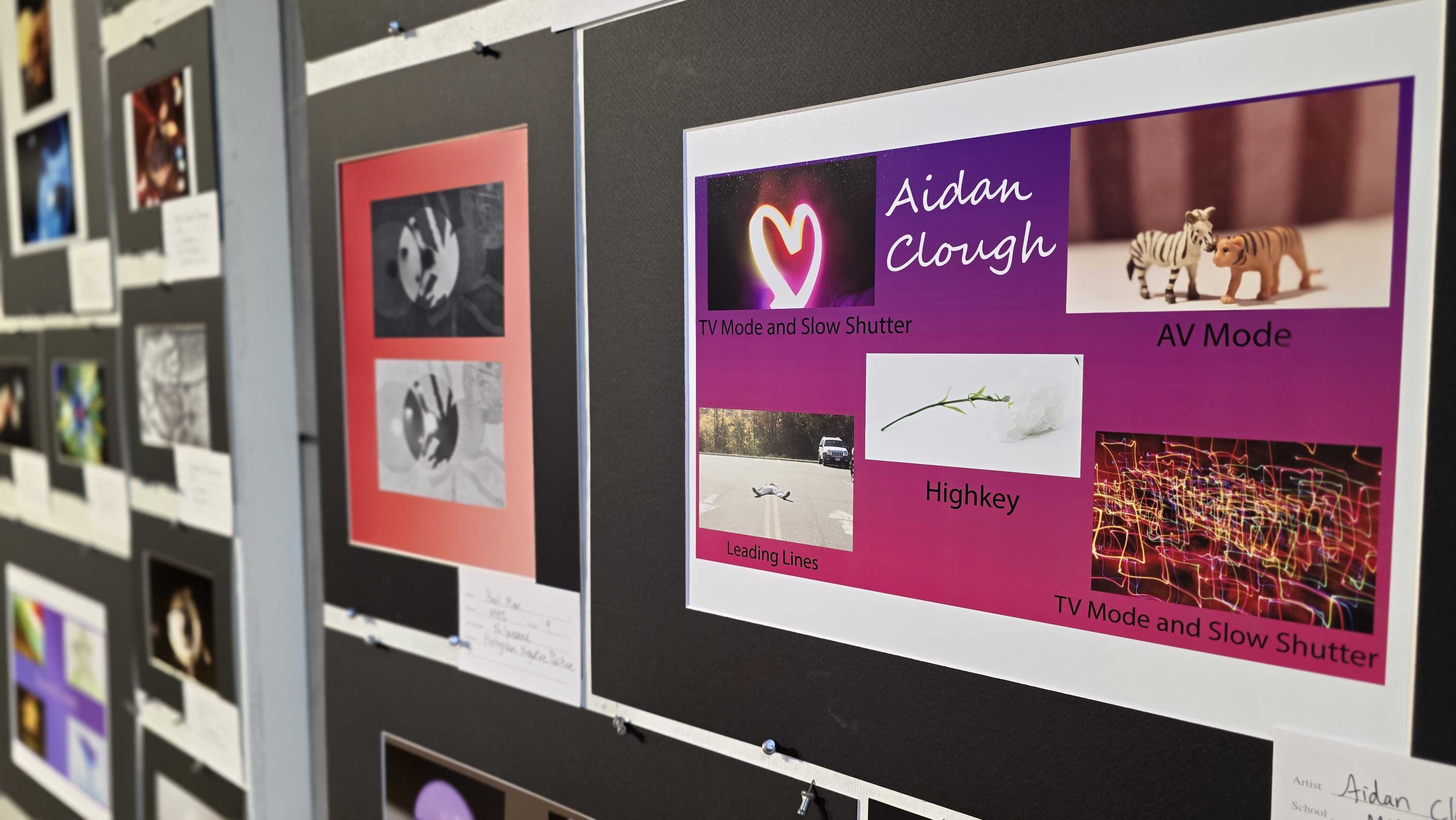 A wall display showcases various framed artworks and photographs, including a prominent purple and pink collage.