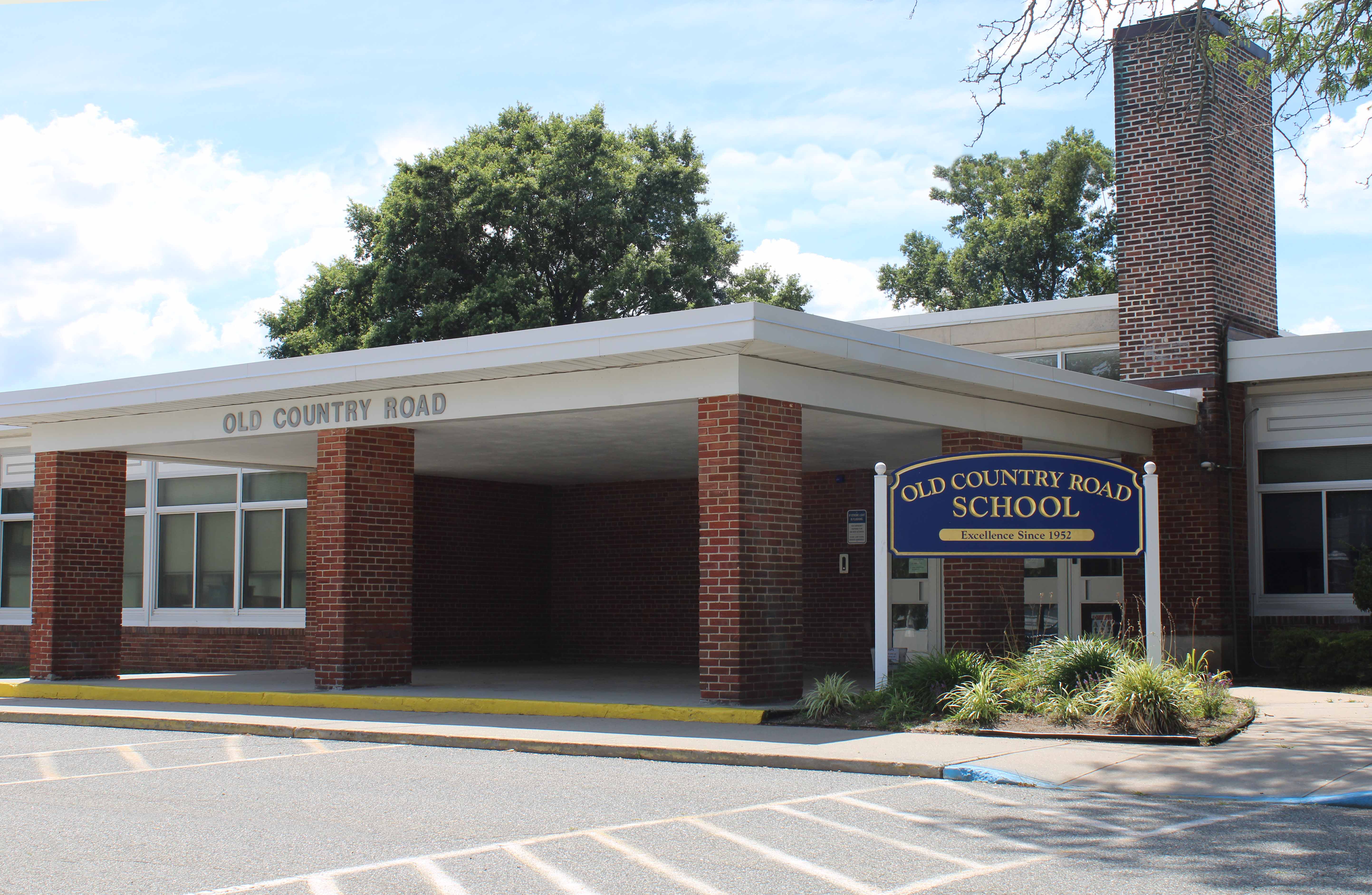 Exterior view of a brick school building with a covered entrance and a sign that reads 'Jefferson Elementary School'.