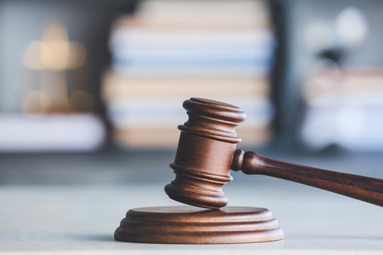 A wooden gavel rests on its sounding block, symbolizing justice.