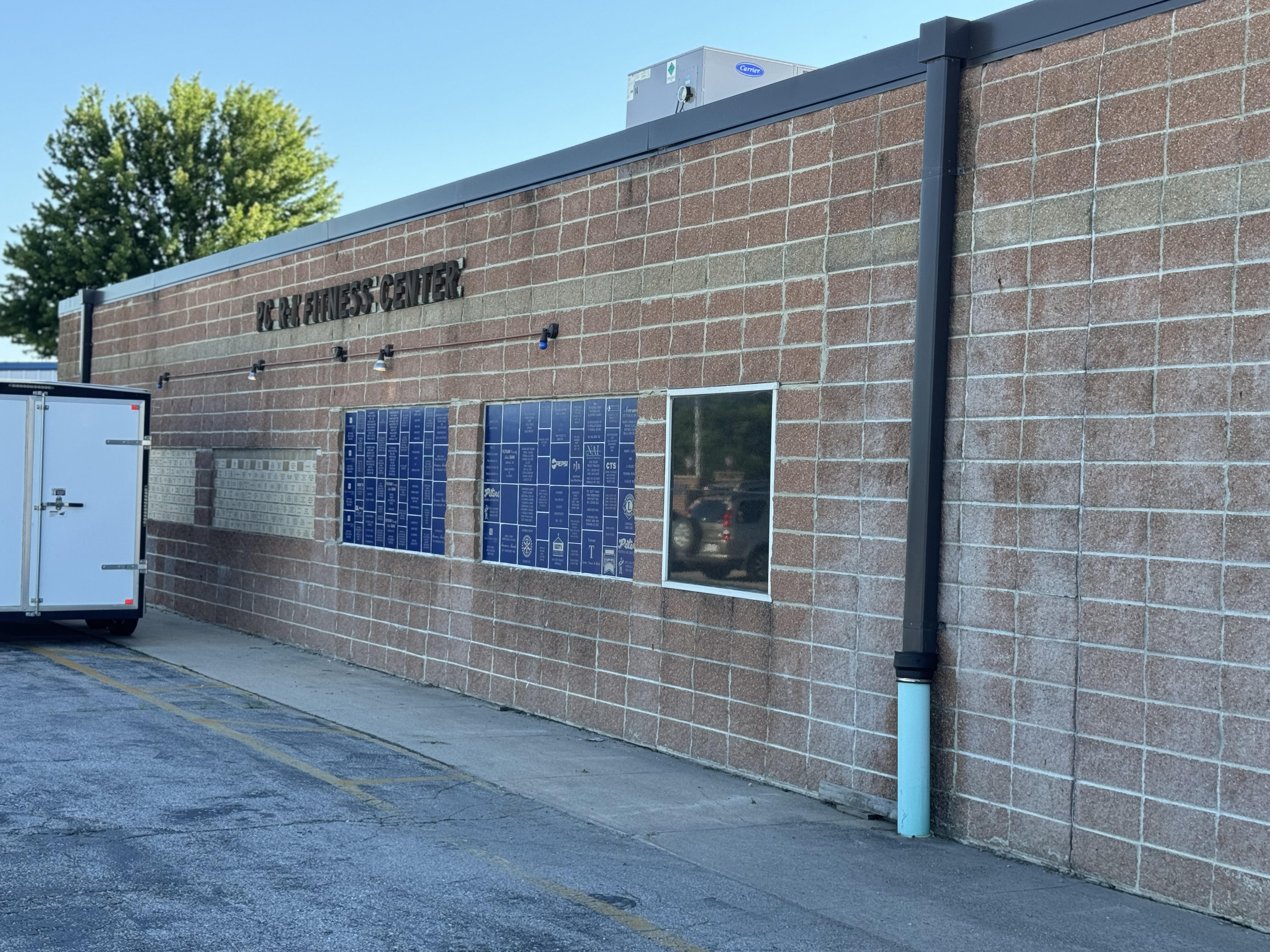 Exterior of the Putnam County R-I Fitness Center with building lettering and blue recognition plaques.