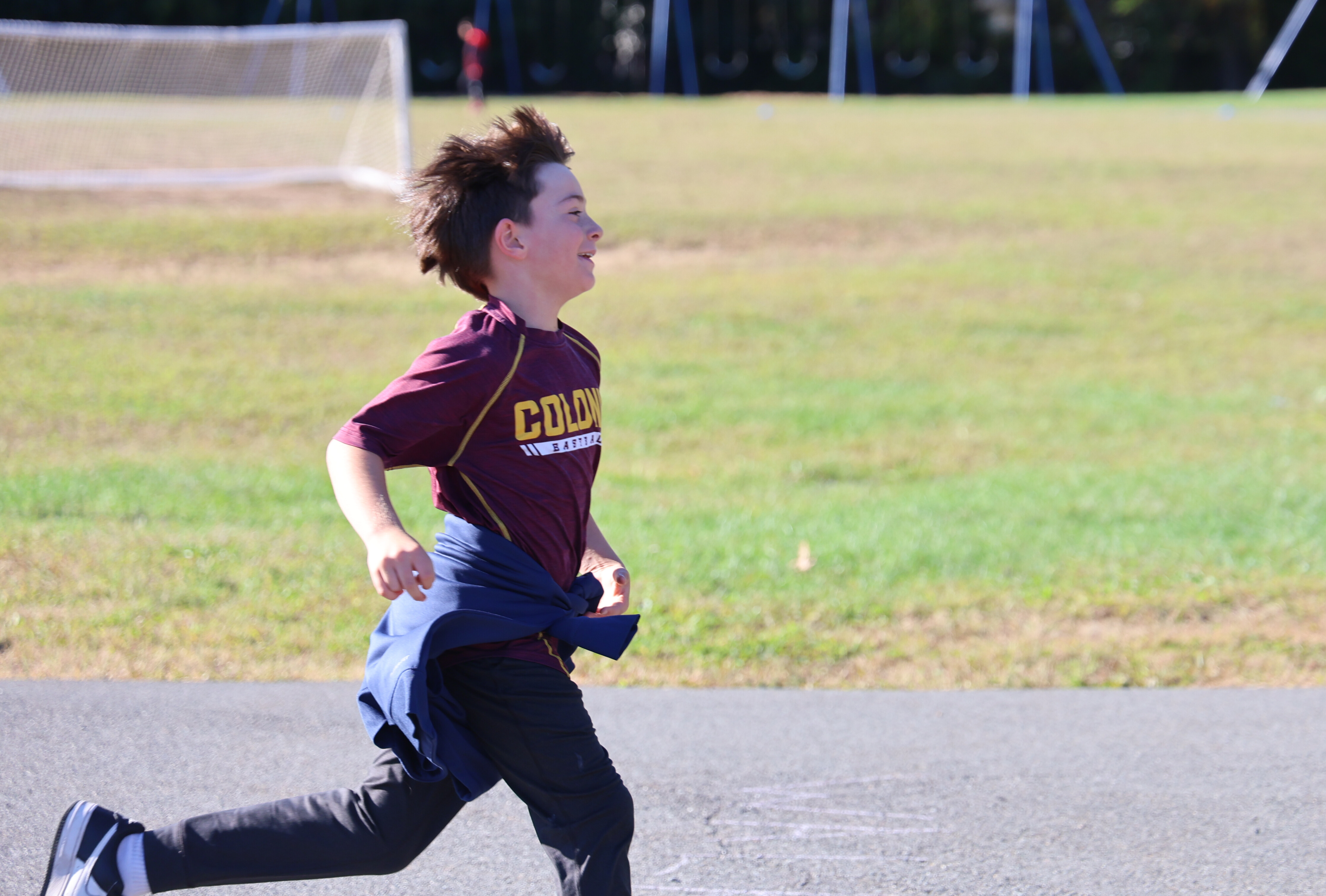 A young person runs on a track, focused and determined.