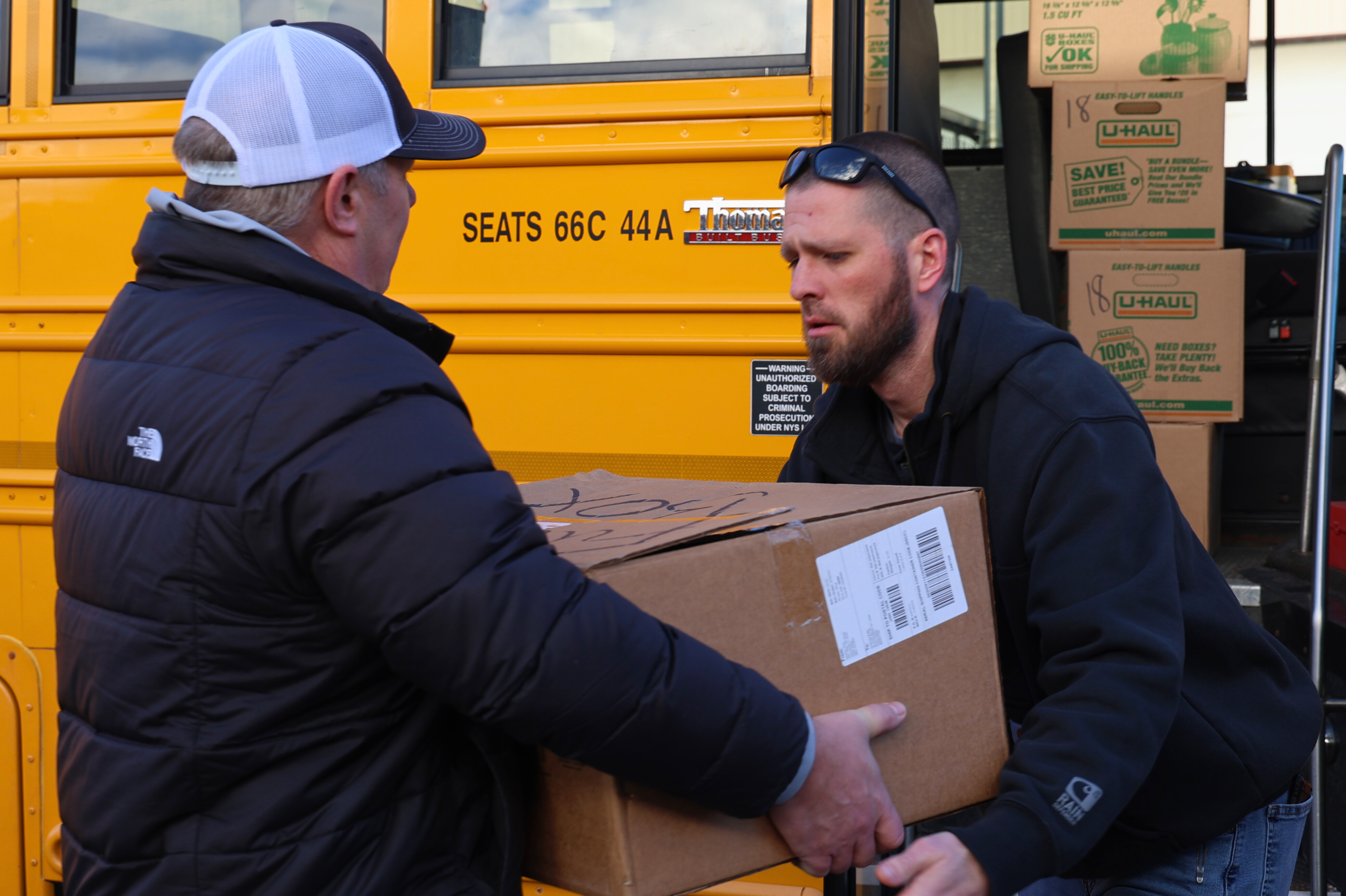 Bill Boardman and Kyle Bartlett loading school bus