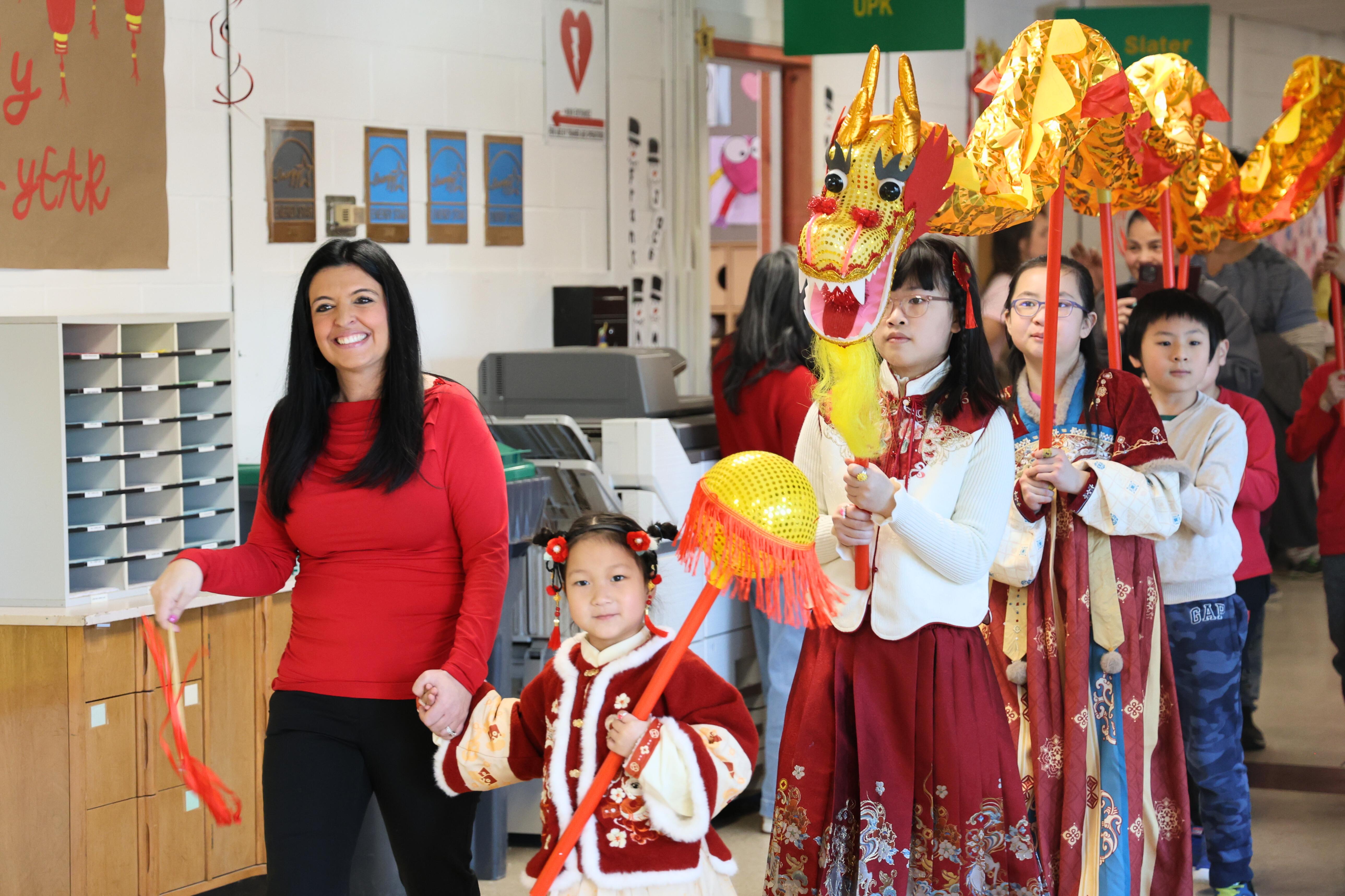 ENL teacher Vanessa Mauriello leads Lunar New Year parade with students at Veeder Elementary