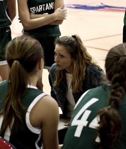 Woman coach discussing a play with her team
