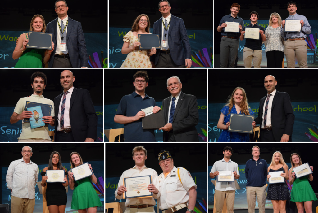 A group of students and adults stand on a stage, holding certificates and awards.