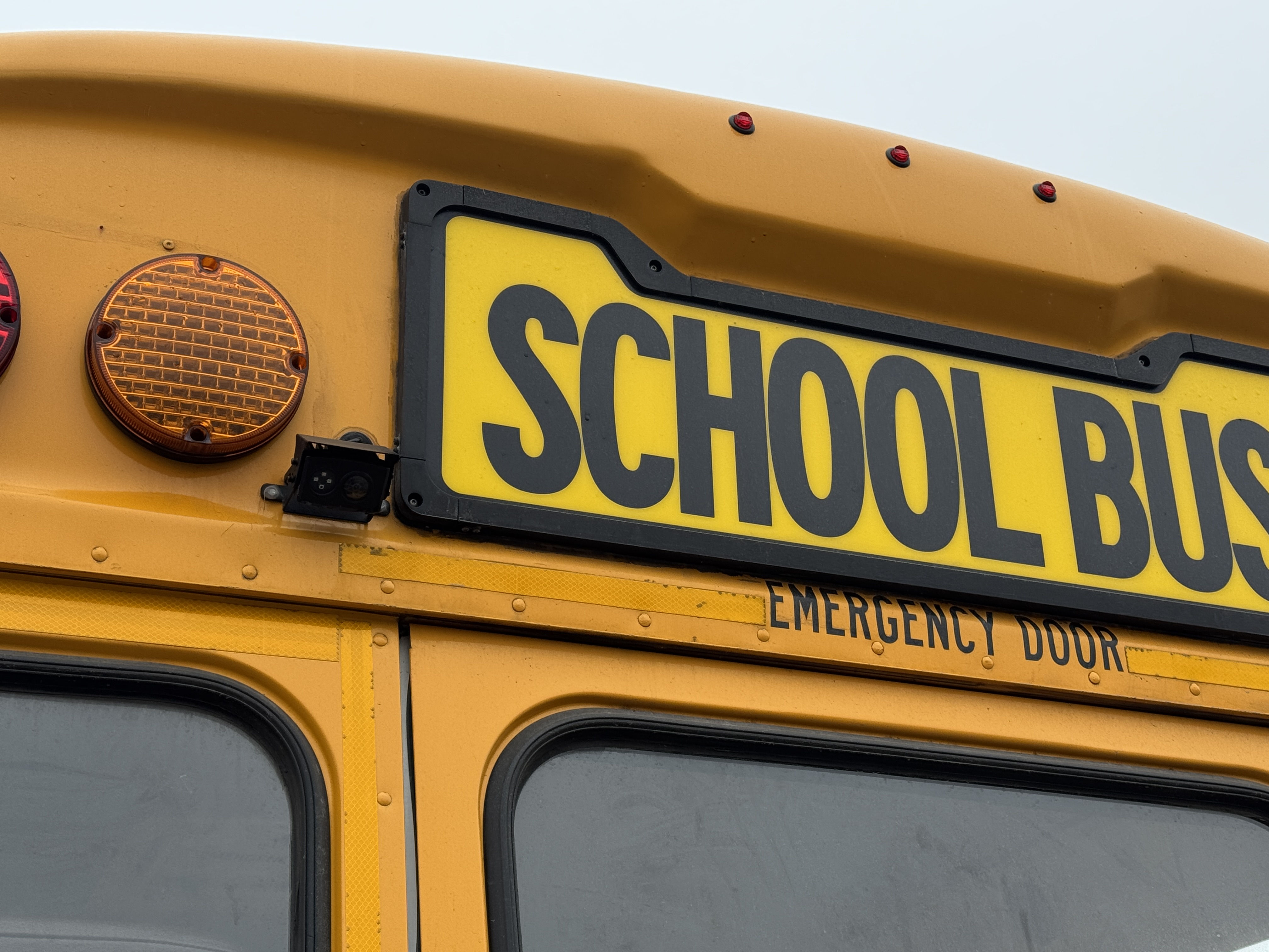 Close-up of a yellow school bus with the words 'SCHOOL BUS' prominently displayed.