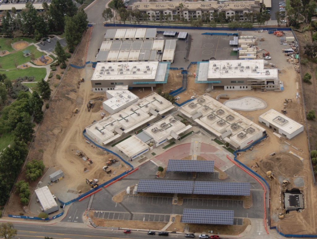 An aerial view of a school campus complex with multiple buildings, courtyards, and parking areas.