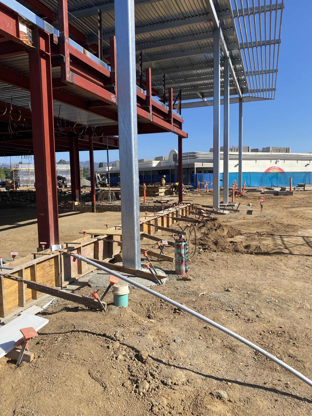 Construction site with exposed steel beams and concrete foundations.