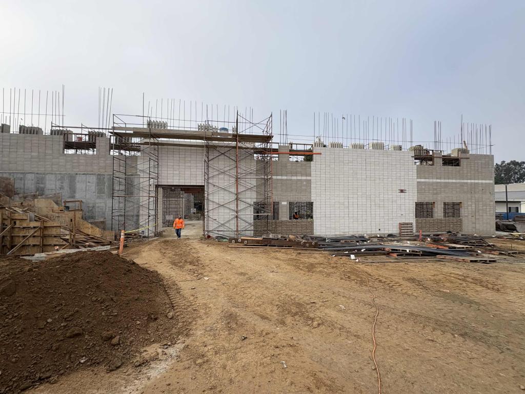 A building under construction with scaffolding and exposed concrete blocks.