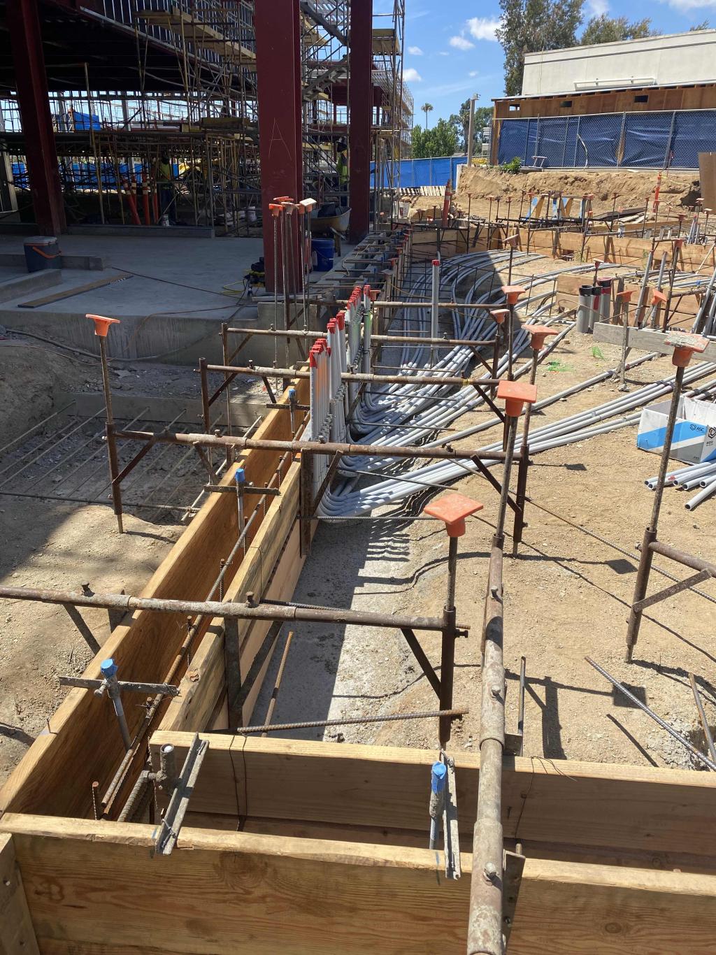 Construction site with wooden forms and metal supports.