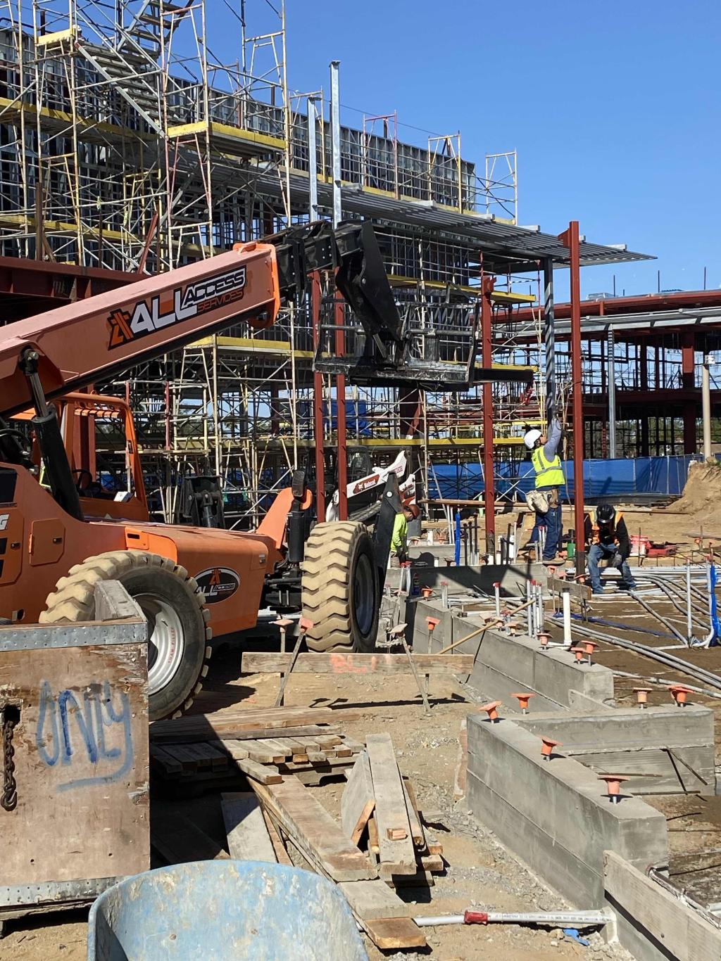 Construction workers are busy on a large building site.