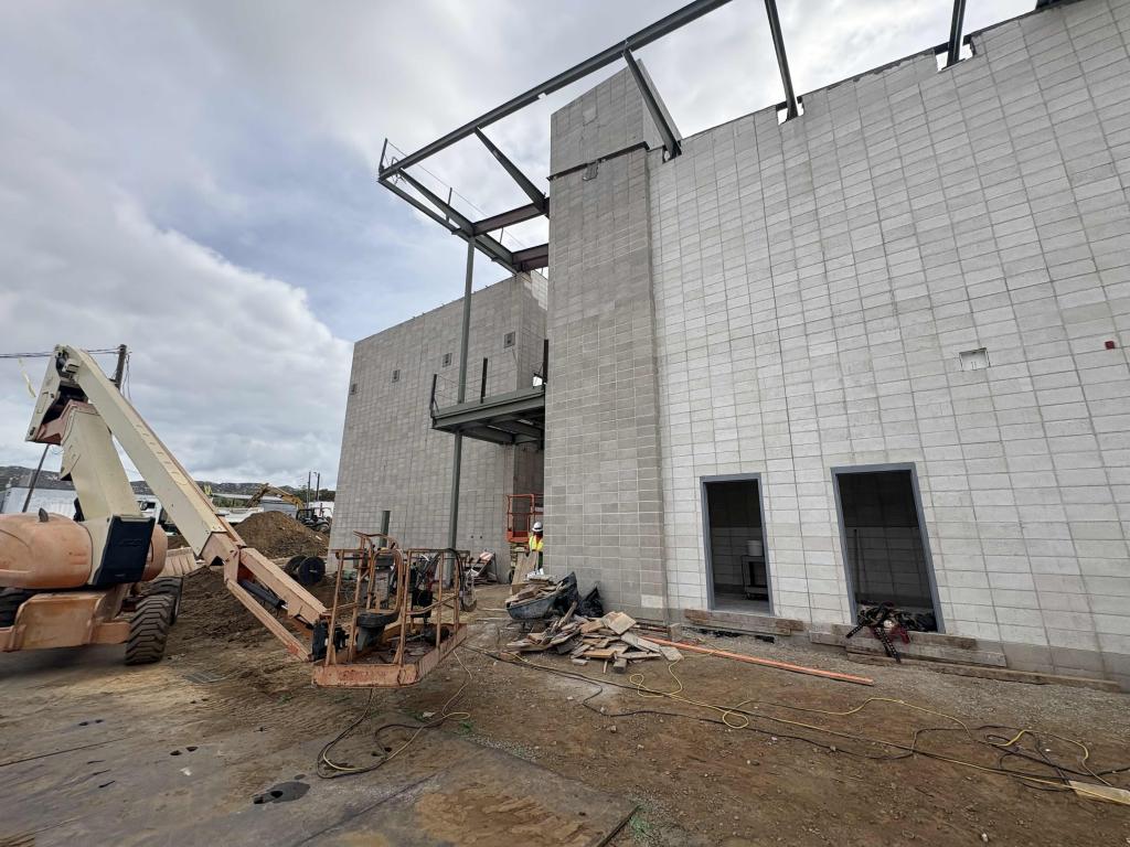 Construction site with a partially built building and heavy machinery.