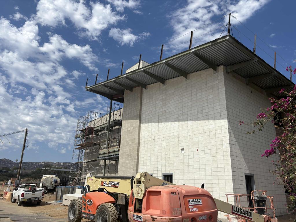 A multi-story building under construction with scaffolding and heavy machinery on site.
