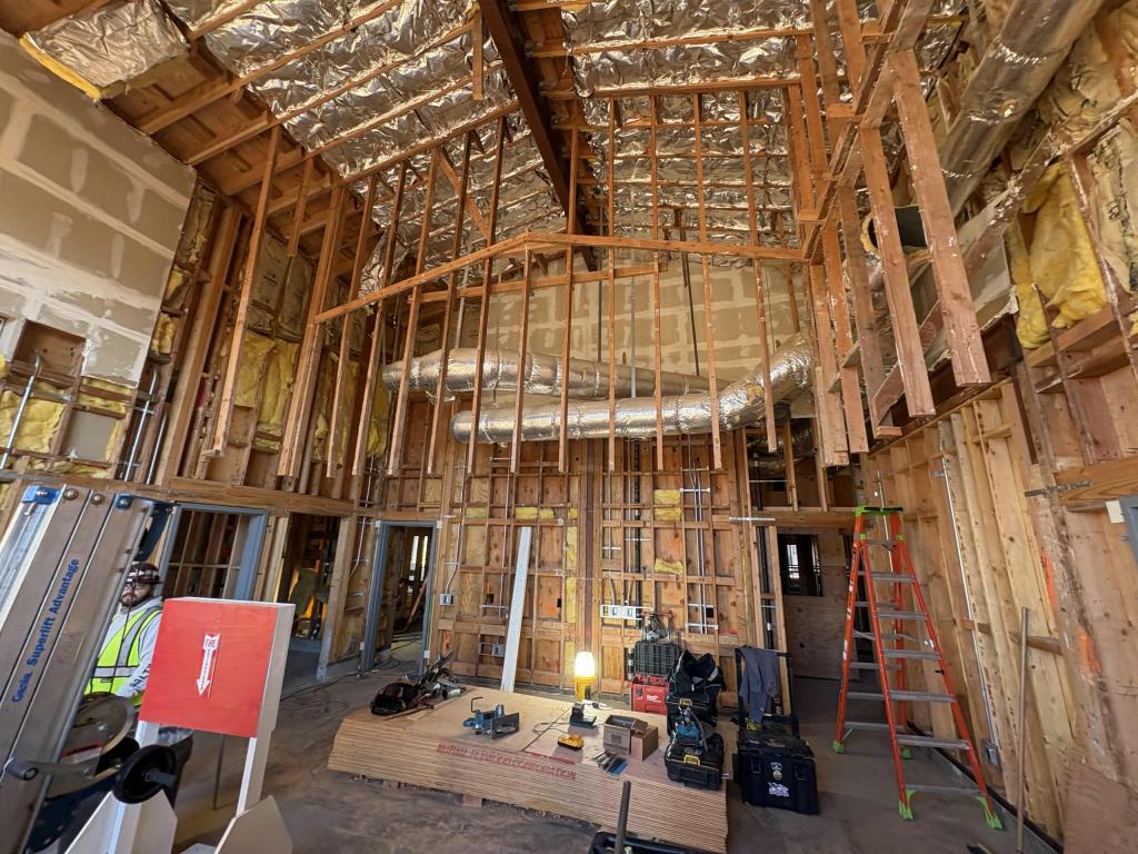 A room under construction with exposed wooden framing on walls and ceilings.