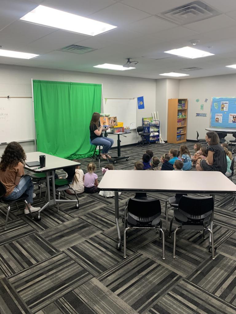 Children listening to a teacher reading a book 