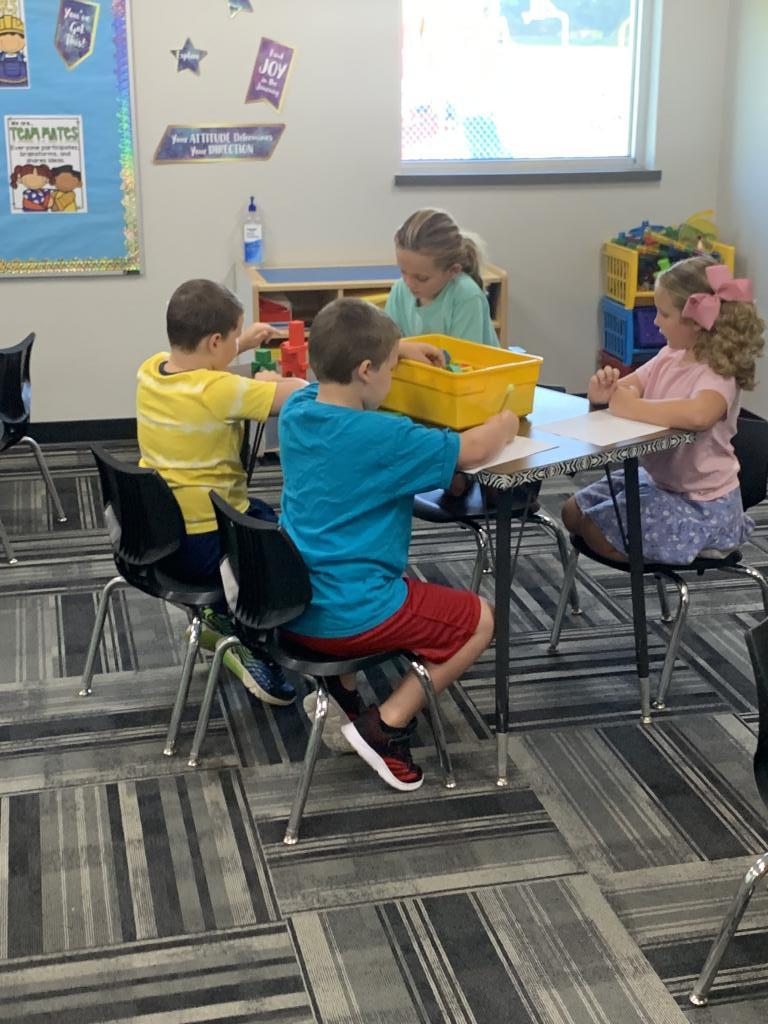 Children at a desk doing a hands on activity together