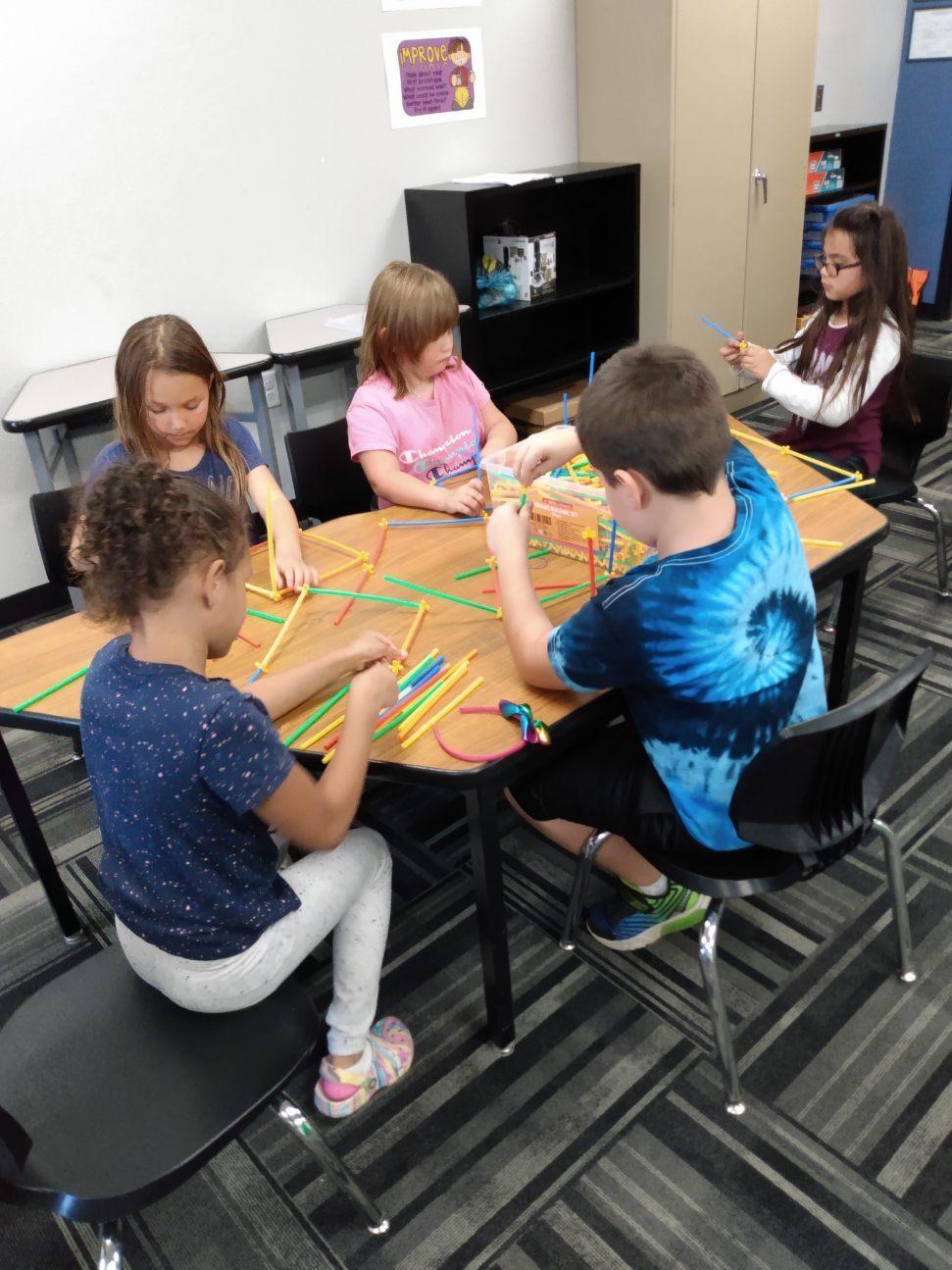 Children playing with building straws together