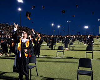 VHS Graduates throwing their caps into the air
