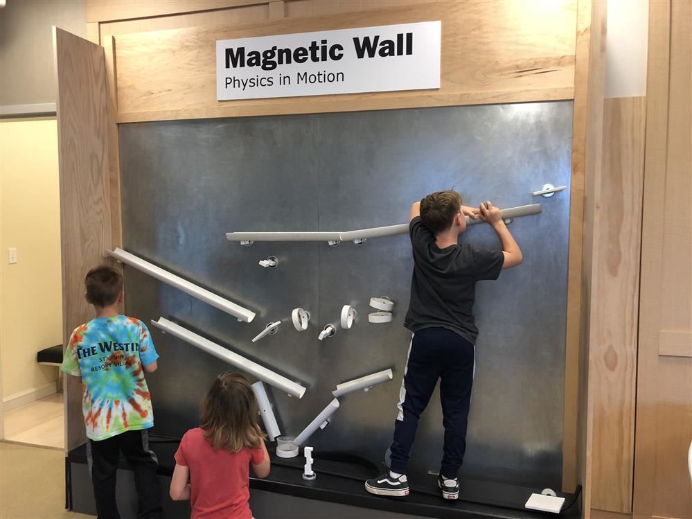 Children interact with a magnetic wall at Long Island Science Center.